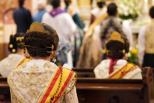 Falleras attending a traditional religious event during the Fallas festival in Valencia.