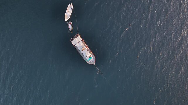 Top down aerial view of a boat with dinghies anchored off the coast of San Evaristo.