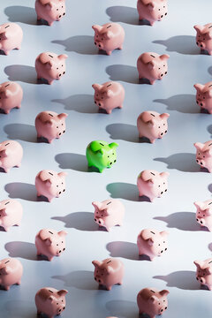 Green Piggy Bank Standing Out from Pink Crowd