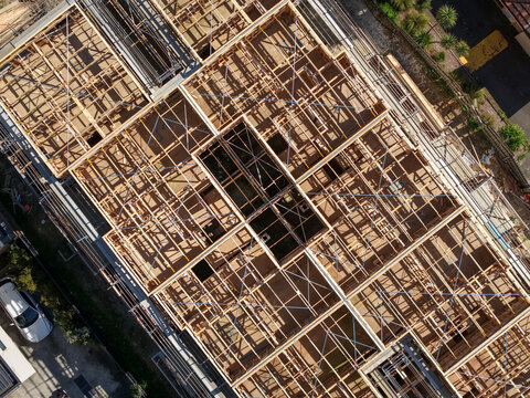 Aerial view of the wooden structural framework and metal bracing of a building under construction in Melbourne, VIC, Australia.