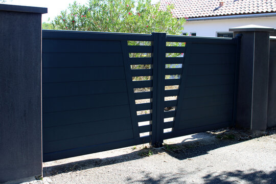 Portail automatique double battant en aluminium gris anthracite avec lattes horizontales et motif g&eacute;om&eacute;trique ajour&eacute;