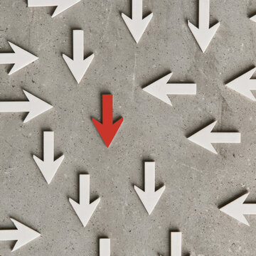 White paper arrows pointing in different directions on gray concrete background, concept of choices, decisions and diverse paths, on red down arrow