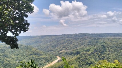Panoramic view of a winding river through lush tropical mountains and forested valleys in Indonesia © TsaqibNabil
