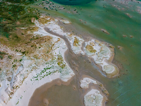 Aerial view of the Baie d'Authie coastal landscape with sand dunes, tidal channels, and green vegetation in Fort-Mahon-Plage, Hauts-de-France, France.