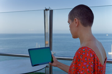 Woman holding tablet with green screen outdoors © Pawel