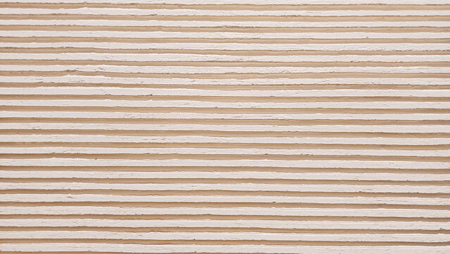 Beige horizontal ribbed texture background with parallel corrugated plaster lines.