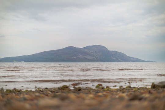 Misty shore meets calm, grey waters