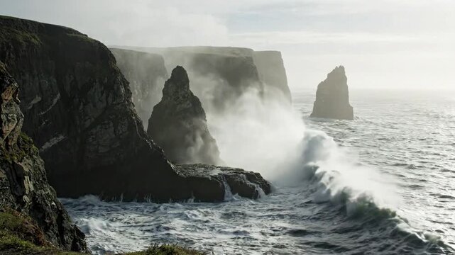 Dramatic ocean waves crash against rugged sea stacks and misty cliffs on a cloudy day