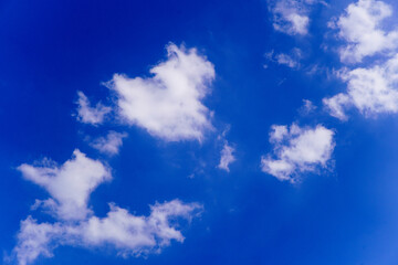Fototapeta premium Vibrant Blue Sky with Scattered White Cumulus Clouds on a Sunny Day