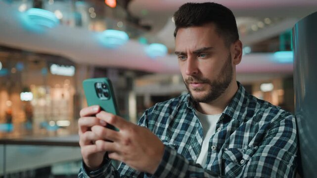 Serious Caucasian business man using mobile phone social media chat scrolling online application male client businessman browsing smartphone cyberspace chatting with cellphone device in shopping mall