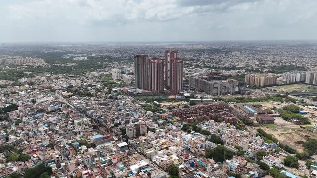 Aerial view of SPR City high-rise development in Perambur, Chennai, featuring distinctive red-and-white apartment towers, landscaped areas, construction activity, and a vast densely built-up cityscape