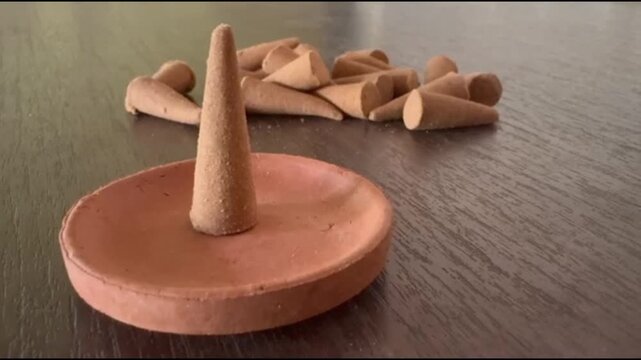 Natural Organic Dhoop Incense Cones with Terracotta Clay Holder Stand on Wooden Table creating a peaceful, holistic wellness setting.