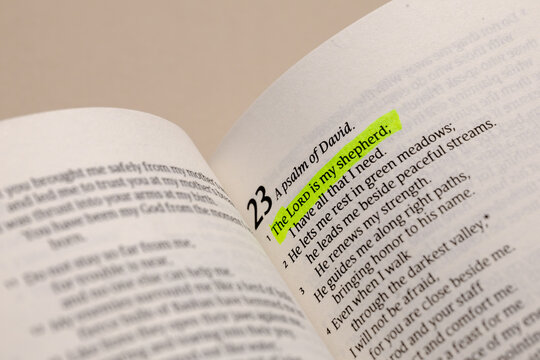 Close-up view of an open holy book with a highlighted bible verse about faith and devotion, featuring spiritual text for study and prayer