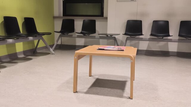 Empty waiting area in a public administrative space with chairs and a table holding some materials