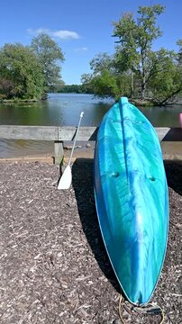 Blue kayak canoe by beautiful State Park lake landscape calm flowing water, aquatic plants woodland nature background, lush green foliage. French Creek State Park Hopewell Lake recreation, copy space
