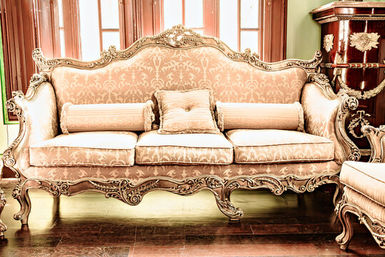 Elegant Baroque-style sofa with a hand-carved wooden frame and upholstery in beige and gold tones. Antiques, vintage furniture