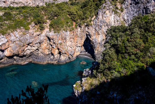 Man looking at Arcomagno natural arch and beach in San Nicola Arcella, Calabria, Italy