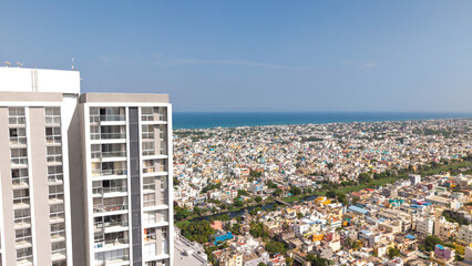 Tall high rise residential tower with the city and sea beyond aerial coastal cityscape © VisualTreat12