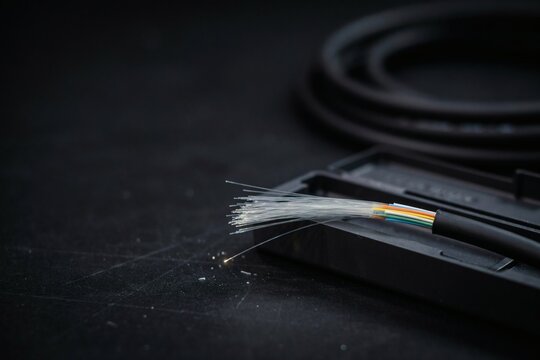 Bare glass fibres fanned from a cut cable sheath into an open splice tray