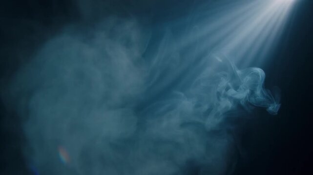 Mysterious swirling smoke plumes illuminated by a dramatic theatrical spotlight create an atmospheric and evocative visual effect with ethereal wisps dancing in the concentrated light beam