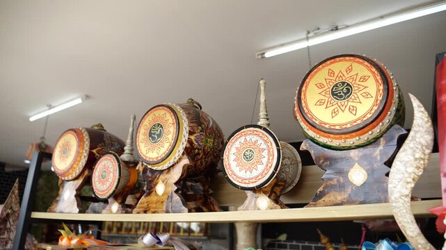 Close up of small decorated traditional Thai drums with intricate painted patterns on display.