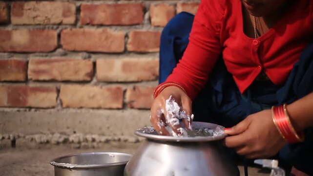 Rural Indian women extracting fresh white butter from buttermilk using traditional bilona method which is traditional Vedic process of making pure desi ghee by churning curd instead of directly using 