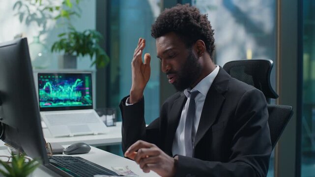 Upset African American business man counting money sad with low salary tired stressed with computer at office. Ethnic businessman male guy employer count banknotes frustrated with financial crisis