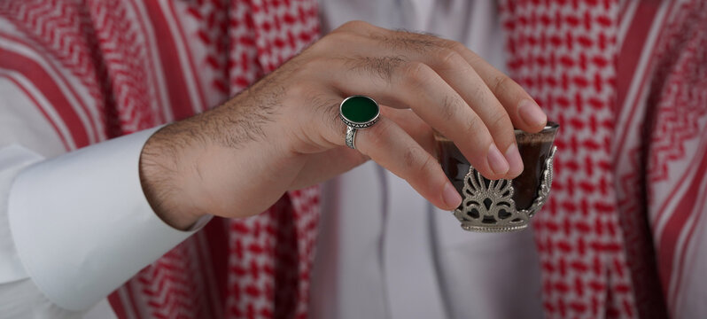 Traditional Middle Eastern man in keffiyeh displaying a ring and prayer beads