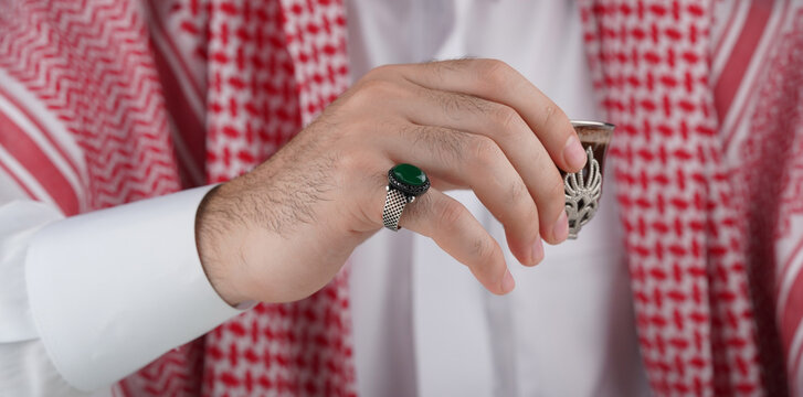 Traditional Middle Eastern man in keffiyeh displaying a ring 