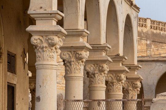 Ornate carved capitals crown a row of columns along the arched gallery of an Ottoman architecture building, Northern Red Sea, Massawa, Eritrea