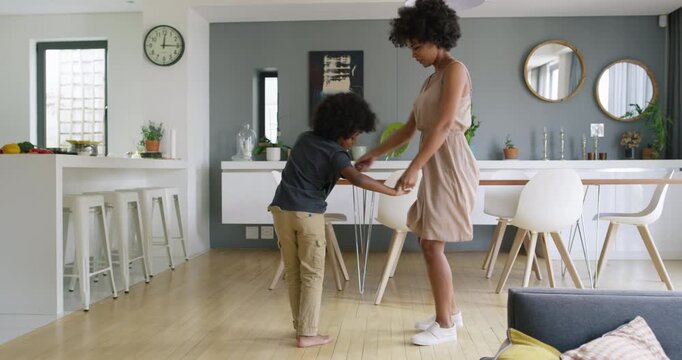 Mother, holding hands and dancing in home with child, love and teaching steps for family bonding. Smile, woman and kid in lounge with rhythm, learning footwork and groovy movement for weekend unwind