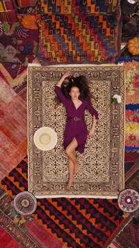 a beautiful girl in dress in a traditional turkish interior with many carpets on the wall