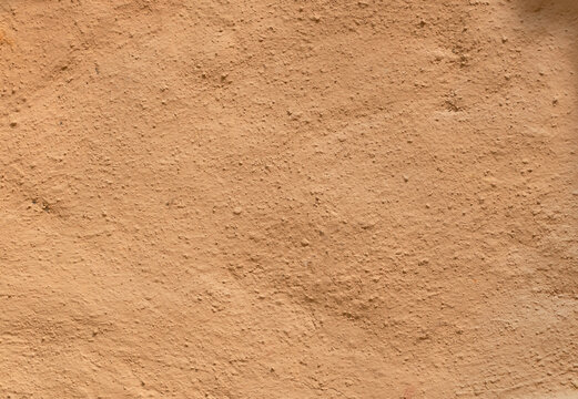 Soil wall texture of adobe house structure and sunlight. Mud background and clay home building. soft picture