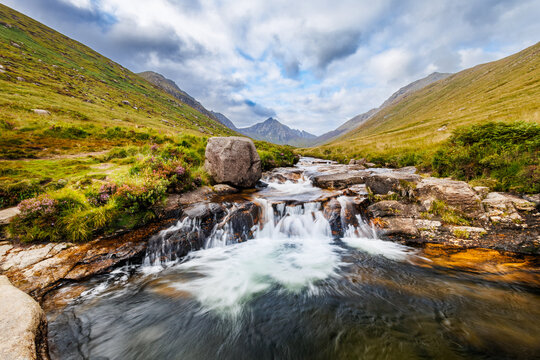 Water cascades over rocks into a serene pool
