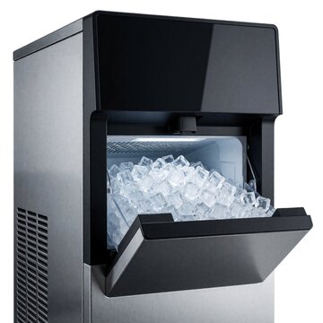 Modern stainless steel ice maker machine is full of clear ice cubes. Commercial appliance for bars restaurants and cafes produces cold frozen water for drinks and chilling food.