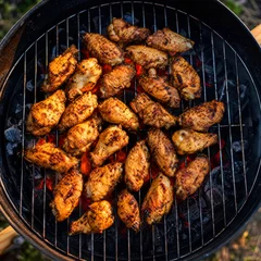 BBQ chicken wings cooking on an outdoor grill © Stuart Monk