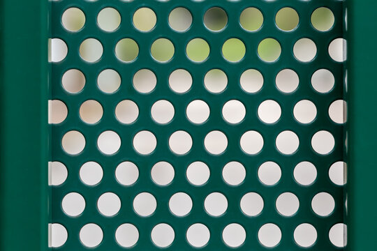 Texture and pattern background dark green perforated metal sheet with circular holes for industrial design and architectural surface concepts