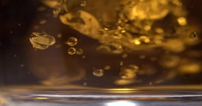 Hot black tea stirring with spoon extreme closeup in slow motion black background