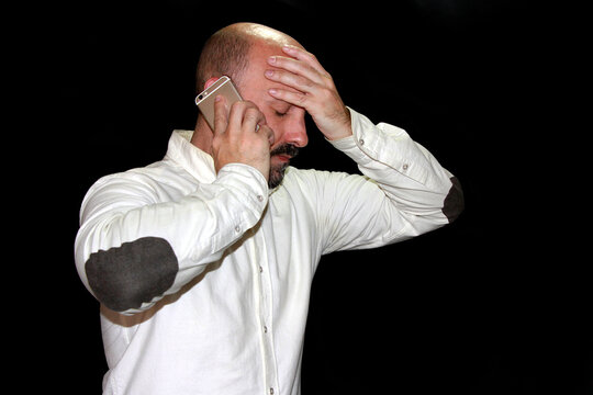 Dolor de cabeza trabajador agobiado con tel&eacute;fono aut&oacute;nomo estresado y m&oacute;vil businessman estr&eacute;s saturado de trabajo con smartphone headache con celular y fondo negro black background