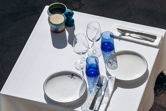 Nice, France - November 11, 2025: Table set with white plates, blue glasses and cutlery at Le Temps d'un Ete beach restaurant near the Promenade des Anglais