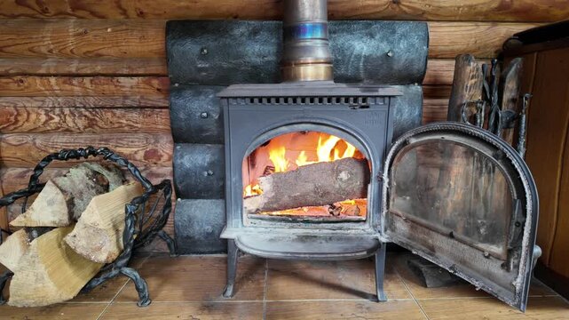 Open Fireplace Stove with Burning Firewood in Rustic Wooden Log Cabin
