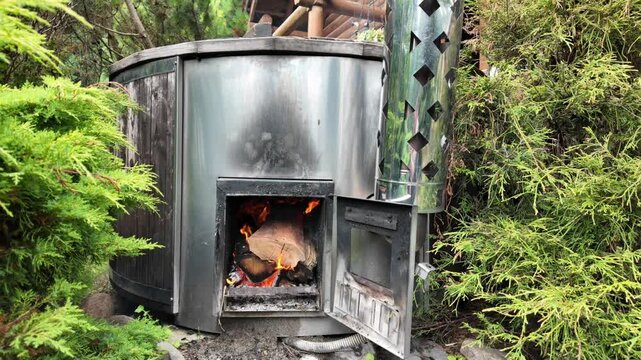 Wood Fired Outdoor Hot Tub Stove Burning Fire in Green Garden