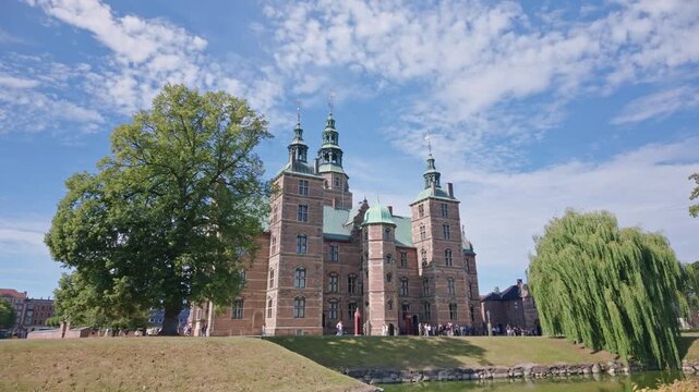 Copenhage, Denmark. August 13, 2026, Historic Rosenborg Castle in Copenhagen, Denmark, with its renaissance architecture and gardens under a blue sky with moving clouds