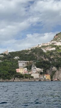 View from the sea of Conca dei Marini village with white houses on the rocky hillside, Amalfi Coast, Italy