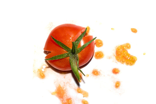 A squashed splattered and crushed broken fresh tomato with seeds