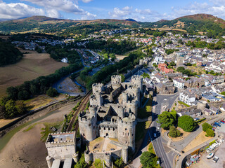 Medieval stone castle and historic town walls, high-angle aerial view. Well-preserved fortress with round towers and battlements next to railway line. © whitcomberd