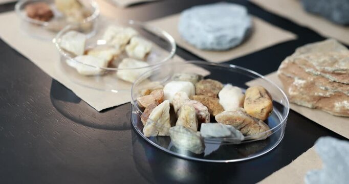 Plastic containers filled with sliced bread and crackers on a dark table, arranged on brown paper for a simple food tasting or snack display.