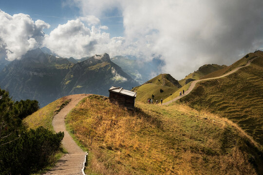 Hikers walking a mountain ridge trail in the Swiss Alps