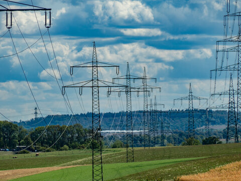 Strommasten einer &Uuml;berlandleitung unter bew&ouml;lktem Himmel