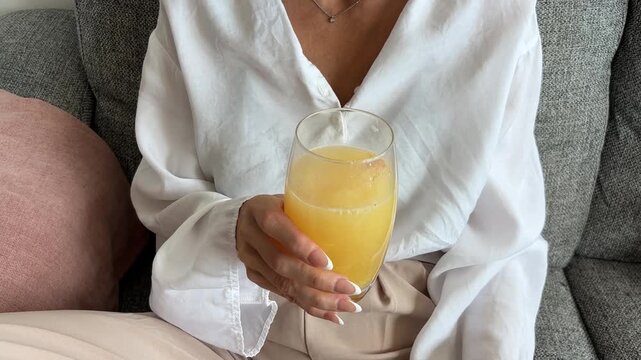 Mujer echando pastilla efervescente en un vaso durante la menopausia